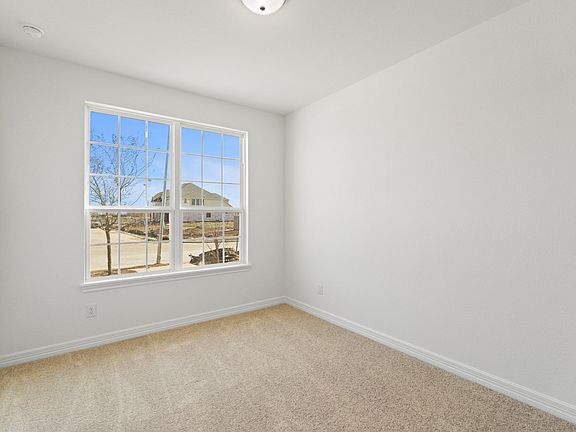 The third bedroom features plush carpet, fresh paint, closet, and a large window that lets in plenty