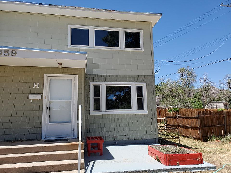 Front view of Unit H with fenced backyard. The garden box is all yours for flowers/veggies.