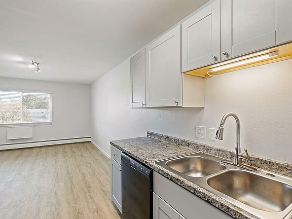 Bright and airy kitchen with white cabinets, sleek granite countertops, and modern sink offering a contemporary feel.