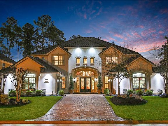 Paver driveway leads to split 2 car garages with wooden garage doors and epoxy coated floors.