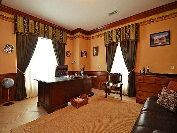 Custom wood wainscoting and matching over sized crown molding make a grand statement in this office.
