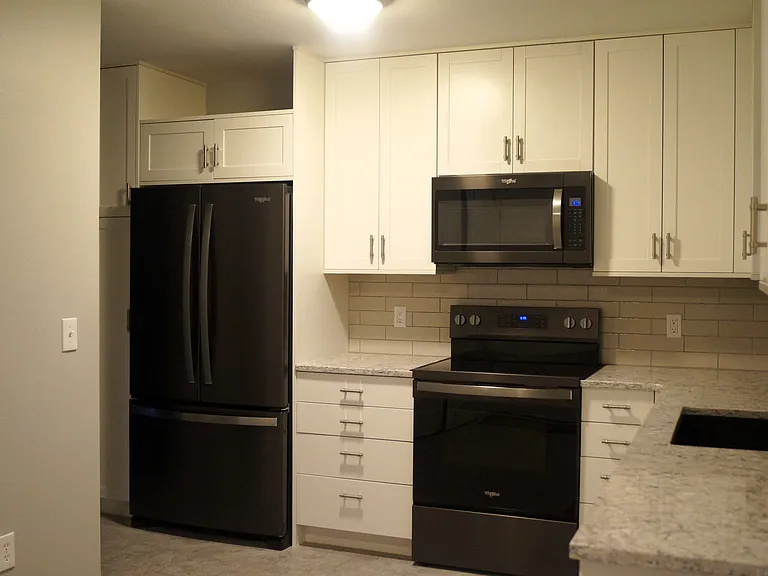 Quality kitchen cabinets, quartz countertops and sink. New black stainless Whirlpool refrigerator with interior water dispenser. New Whirlpool smooth top range.