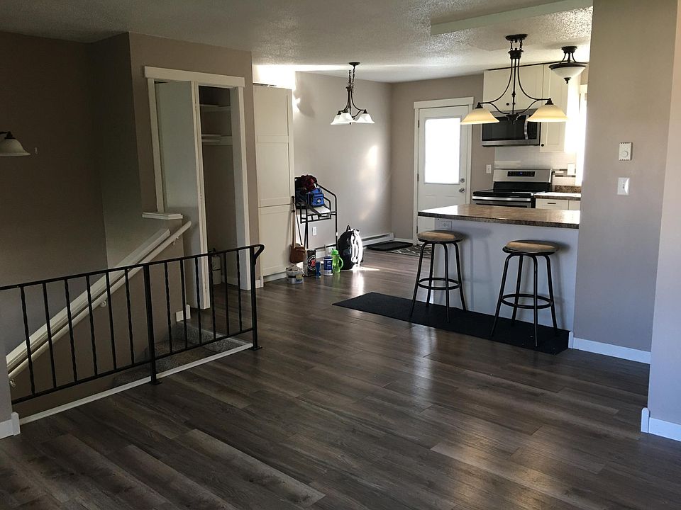 View from upstairs living area, into kitchen. The door opens onto a large, shared deck.