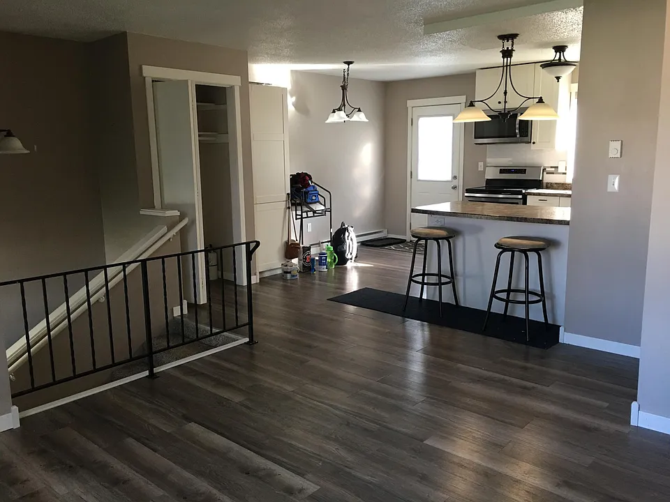 View from upstairs living area, into kitchen. The door opens onto a large, shared deck.