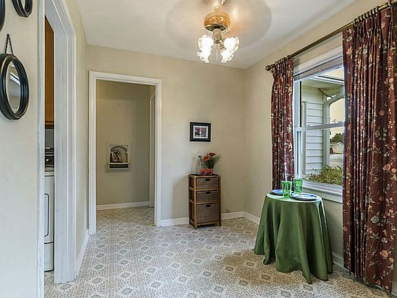 The dining area with laminate floor and lighted ceiling fan.