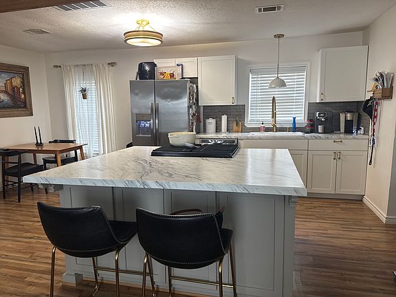 Facing from the living room. Island with lots of storage. Microwave built into island. Light fixtures new.