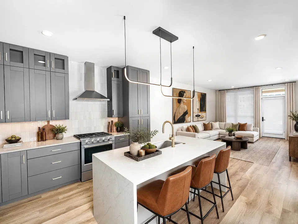 Designer kitchens feature quartz waterfall islands, contemporary cabinetry, stainless steel appliances, and pendant lighting that anchor spacious open-concept living and entertaining areas.