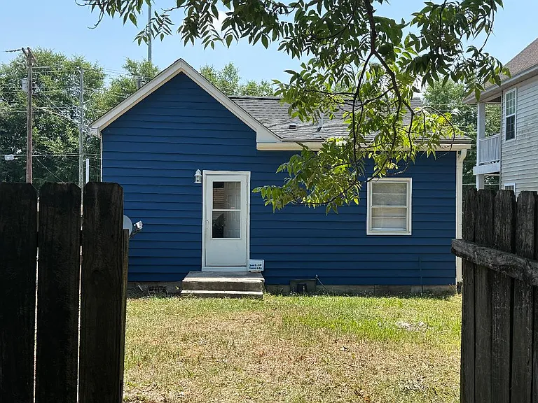 Back of the house from the gates between fenced in yard and back of the lot where off street parking is available.