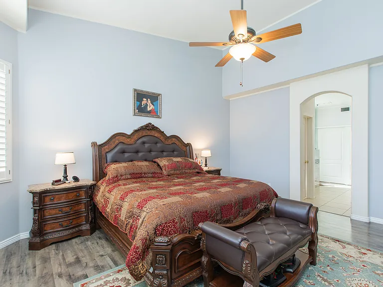 Very spacious primary suite or master bedroom featuring vintage oak wood-look flooring & vaulted ceilings