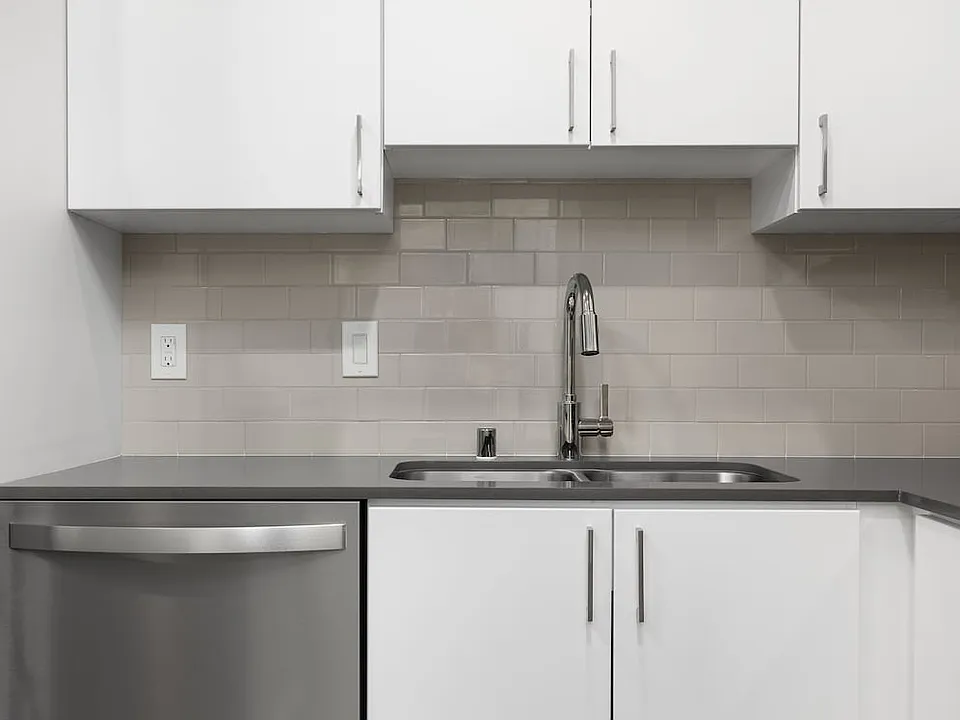 Renovated Package I kitchen with quartz countertops, white cabinetry, stainless steel appliances, hard surface vinyl plank flooring, and tile backsplash