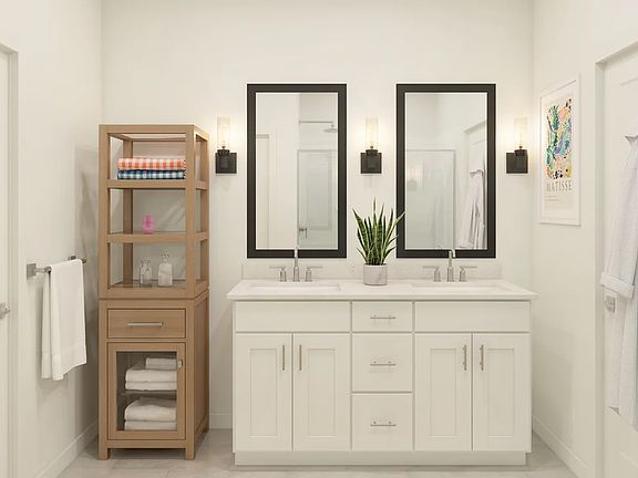 Primary bath with sconce lighting and black-framed mirrors