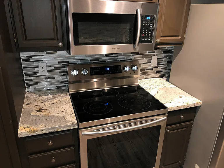 Kitchen and upgraded stainless steel and granite and backsplash.