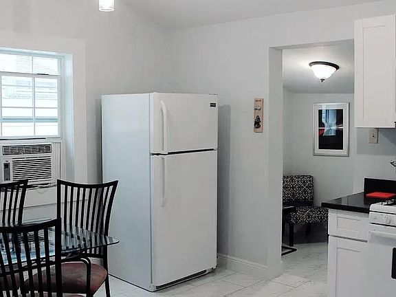 Bright, updated kitchen with vaulted ceilings! Features all-wood cabinets, quartz counter tops, and chic tile floors.