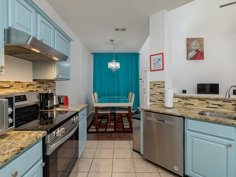 Open kitchen concept with all the major appliances with 2 bar top stools by the pass through. With the washer/dryer in laundry closet.