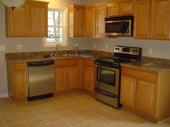 Updated kitchen with new cabinets, tile floor and stainless steel appliances.