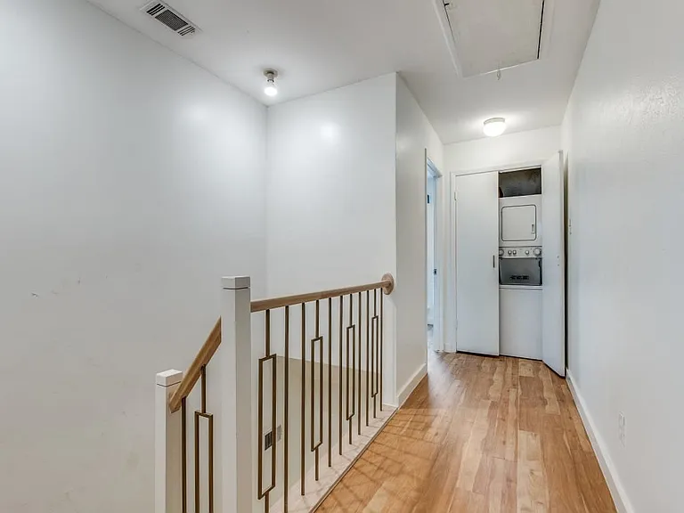 Updated stair railings and view of washer & dryer at the end of the 2nd floor hallway.