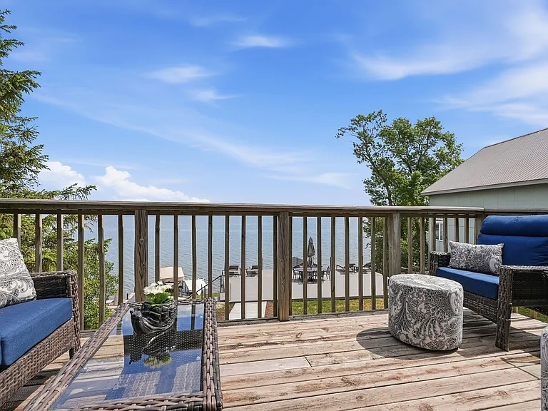 Upper level deck w/ an amazing lake view & cushioned patio furniture.