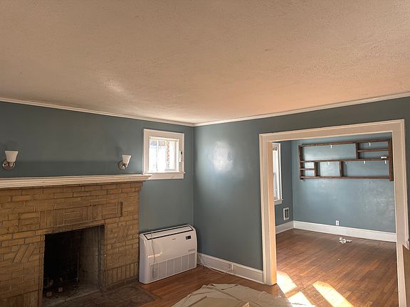 Fireplace in living room with wall sconces, new mini split AC and heat dollar a day very economical very sunny in the afternoon dining room