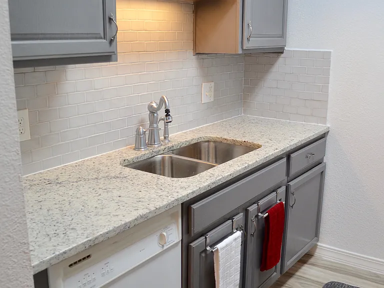 Guest house kitchen sink area and dishwasher. Granite countertops.