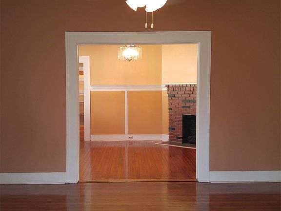 Living room with hardwood floor, coffered ceiling, and view of dining room.