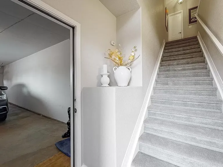 Entryway staircase (currently includes a stair lift) and two-car tandem garage