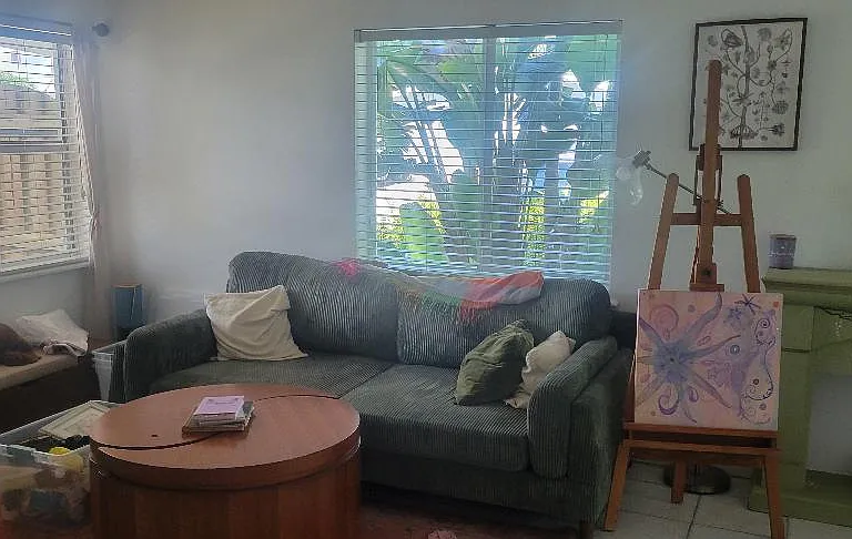 Living room from bedroom door showing more of the windows. East windows are impact slider style.