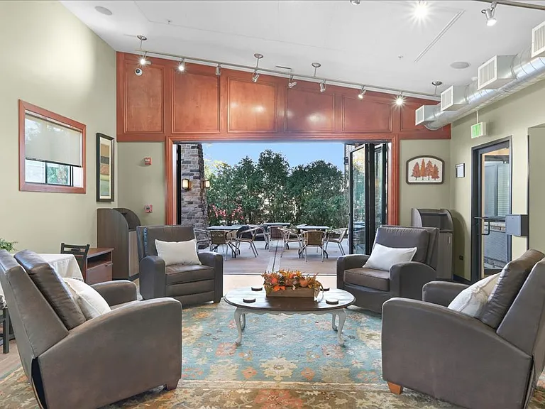 Community gathering room with games, cozy seating, and large dining table for a variety of engageing events.