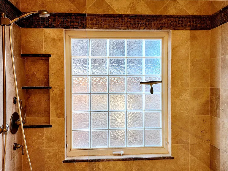 Primary bathroom with beautiful custom tile in walk in shower.