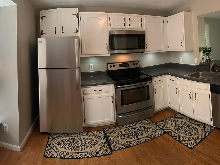 Kitchen, with front door and front view windows to left