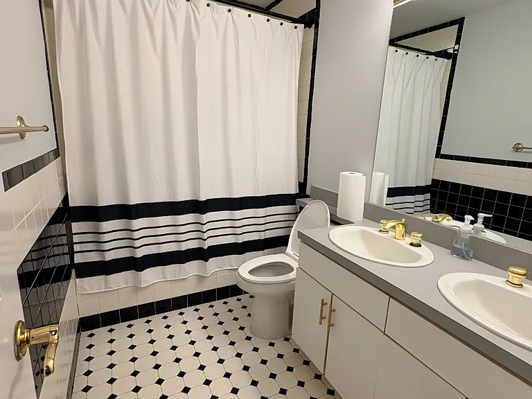 Spacious bathroom with double vanity and full tub/shower.