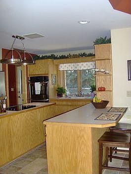 Kitchen island has builtin cook top and storage below for pots and pans.