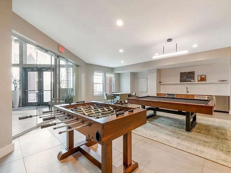Resident lounge game room with entertaining kitchenette, billiards, and foosball