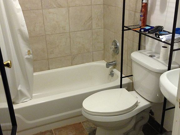 Bath room has brand new tile, push button toilet, and porcelain sink 