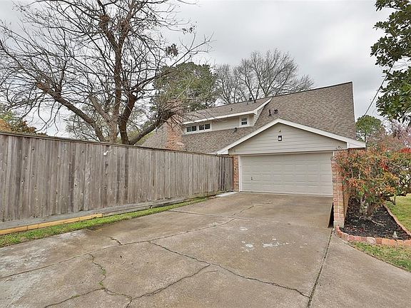 View of rear of hoe with entry into the garage. The garage is large and spacious. The utility is in the garage and the seller will leave the washer and dryer.