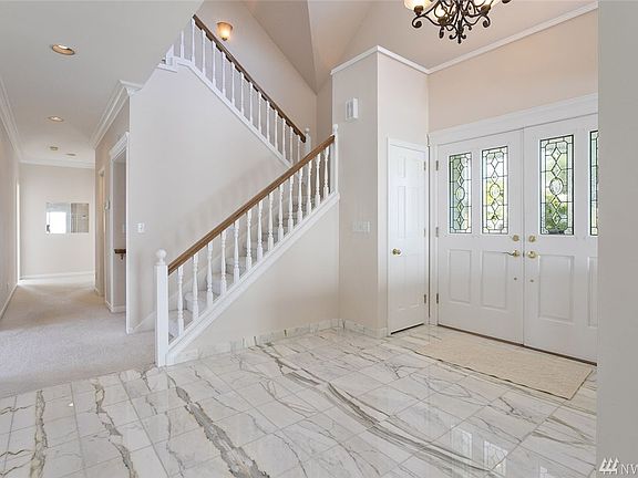 Grand entry with marble tile floor and cathedral ceiling