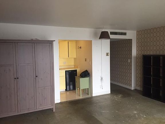 Main living area with views of kitchen and entrance hallway