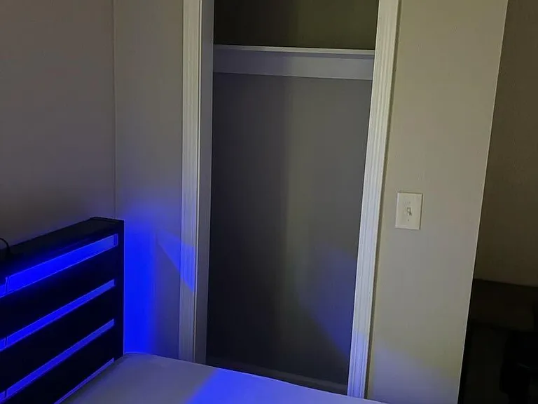 Private bedroom with space for a full/queen bed and an open closet for easy storage and organization.