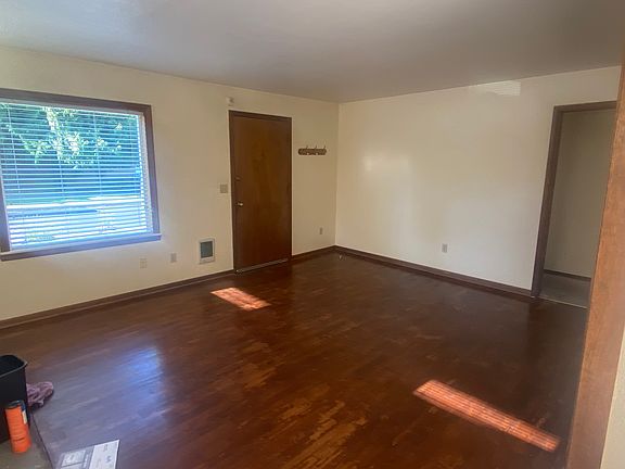 Spacious living room with older hardwood floor.
