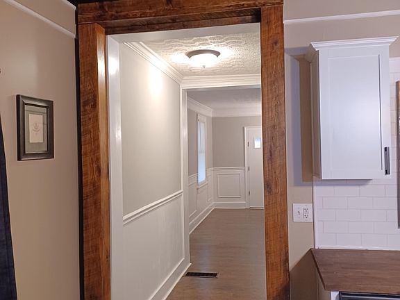 Standing in Kitchen looking through hall into the entry/dining area