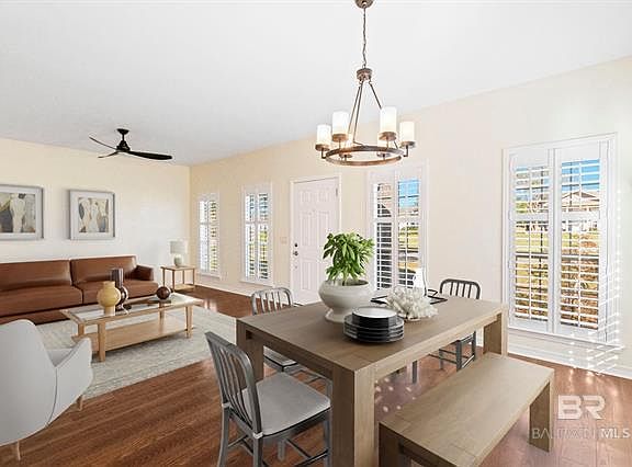 Open concept living/dining room with new flooring, plantation shutters and upgraded lighted with plenty of natural light