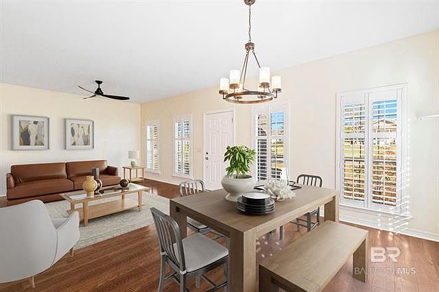 Open concept living/dining room with new flooring, plantation shutters and upgraded lighted with plenty of natural light