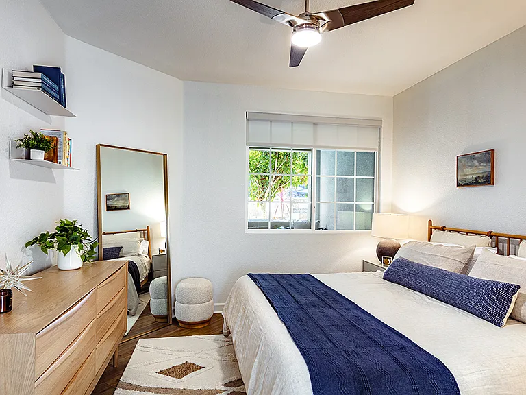 Spacious apartment bedroom with wood-style flooring.