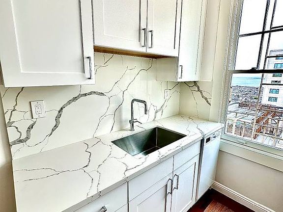 Unit #602 remodeled kitchen with custom cabinetry and gorgeous quartzite countertops!