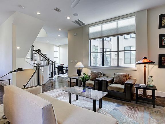 Second floor living room is bright, open and spacious with high ceilings, gleaming hardwood floors, and recessed lighting.