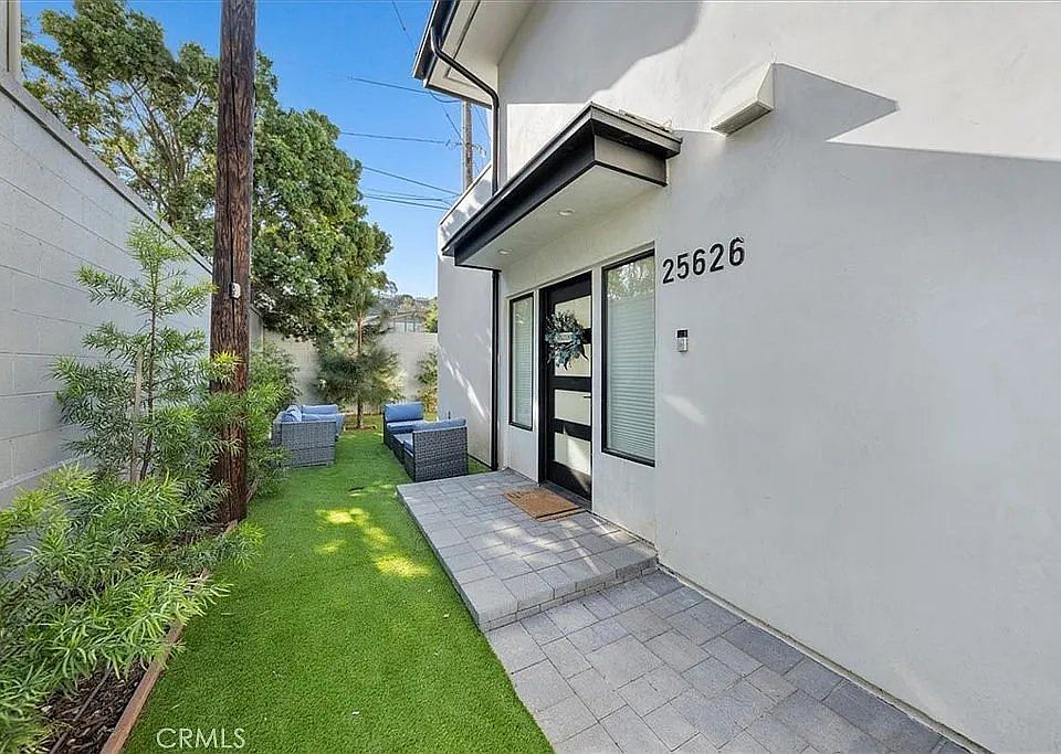 Private entrance with charming front patio and lush landscaping