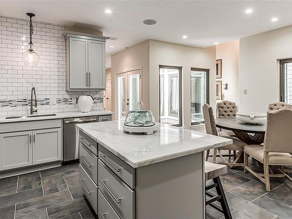 Modern and cool, this gourmet kitchen is top notch with it's high end finishes. Quiet close shaker cabinets in a soft grey and quite close pot and pan drawers offer loads of storage and create much more storage space for large dishes. The overhang is