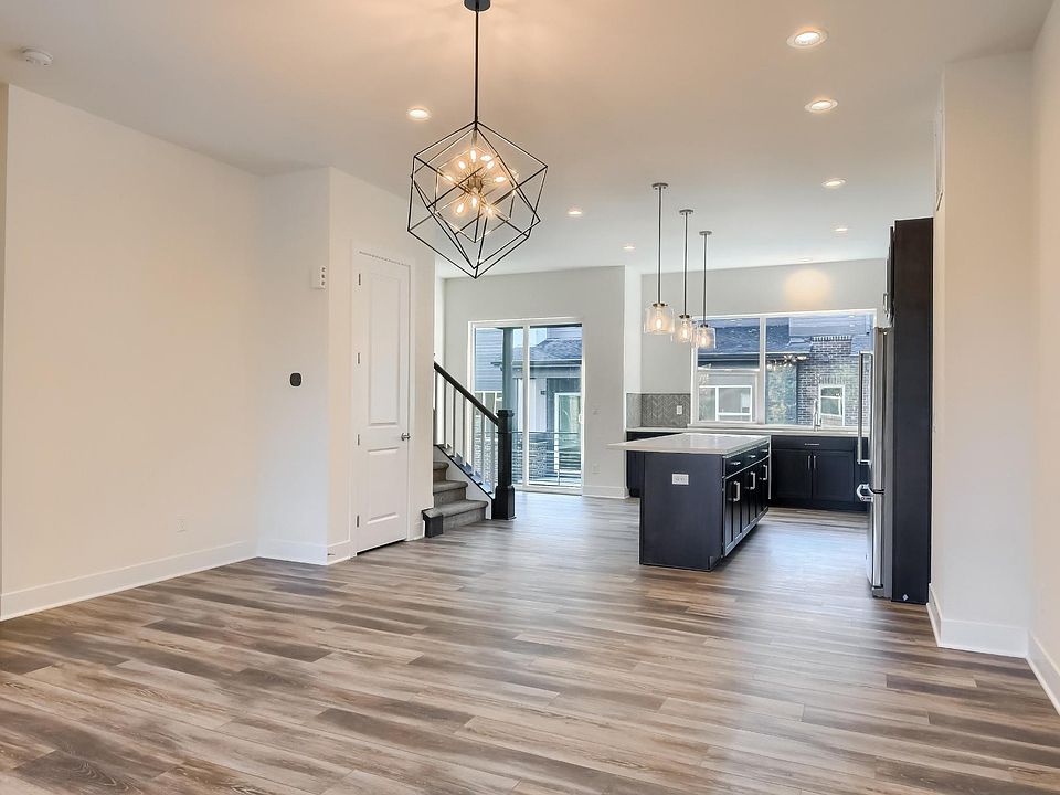 View of dining room, kitchen, balcony door and stairs from living room
