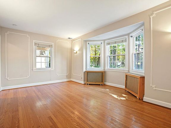 Living Room with Original Moldings, Sconces, Fireplace, a Bay window plus another south facing window. Measures approximately 10'10" X 17'4"