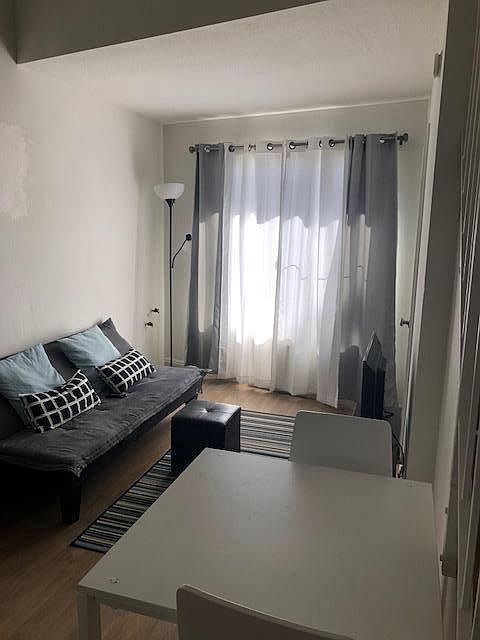 Living area with sofa, pillows, curtains