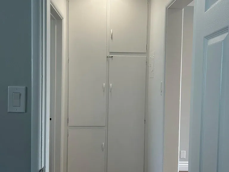 Hallway with cabinets, brand new laminate floor and lighting fixture